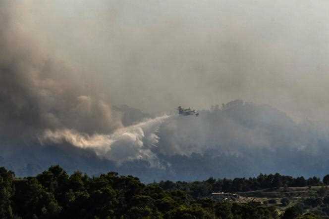 A firefighting plane drops water on forest fires near the village of Alepochori, Greece, May 20, 2021.