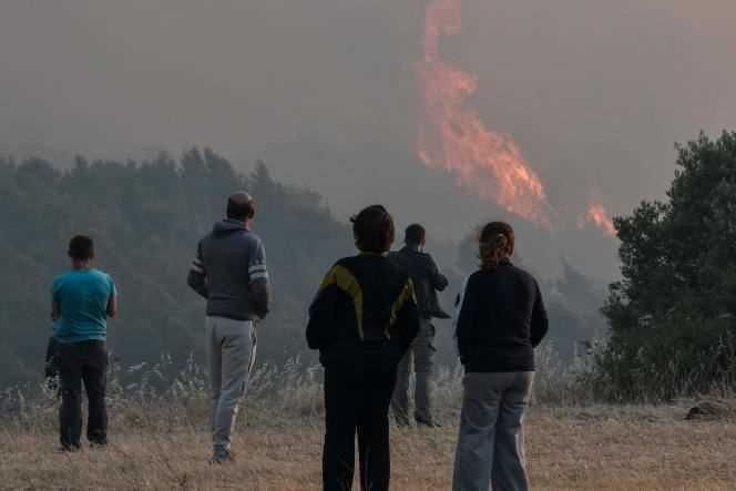 Residents observe a forest fire near the village of Pefkaneas, west of Athens, on May 20, 2021.