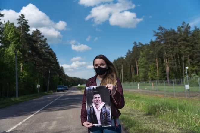 Angelina Goudkova holds a portrait of a Belarusian journalist imprisoned near the border with Belarus, in Salcininkai (Lithuania) on May 27, 2021.