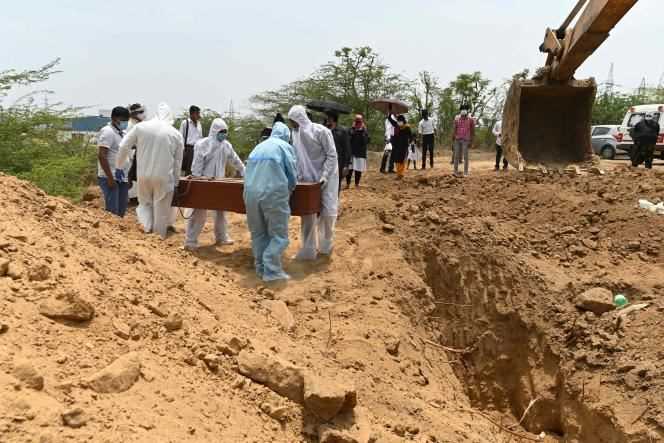 Emergency services bury a victim of Covid-19, in a village near Faridabad.