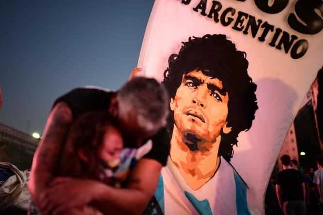 A father and his daughter mourn the disappearance of Argentine footballer Diego Maradona, during a tribute on the day of his death, November 25, 2020 in Buenos Aires (Argentina).