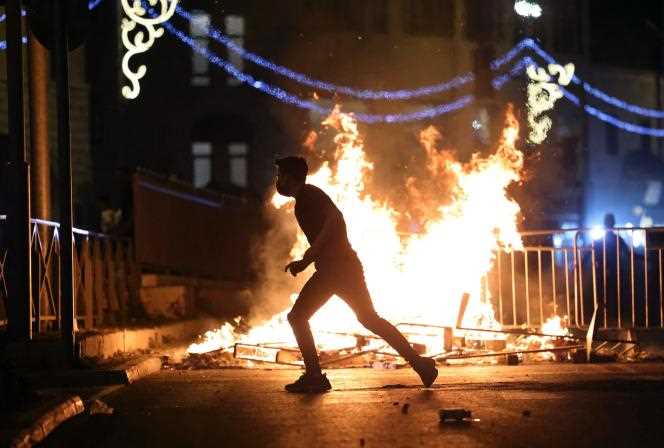 A protester runs towards a burning barricade in the Old City of Jerusalem on Saturday, May 8.