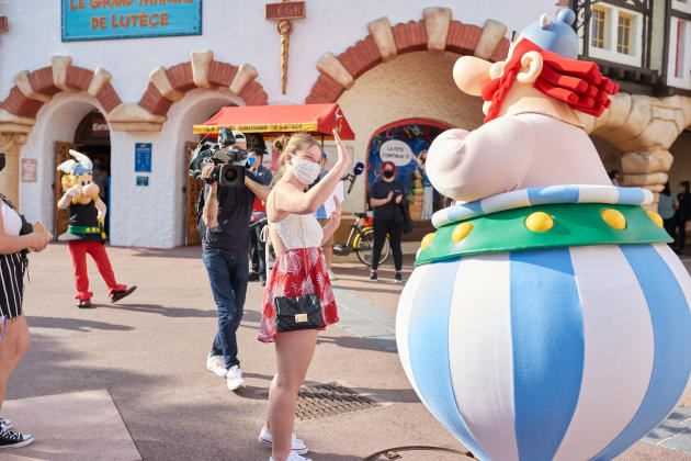 The first visitors arrive at Parc Astérix on June 9, 2021, the day it reopens.  Because of sanitary measures, Obelix cannot respond to a young woman's 