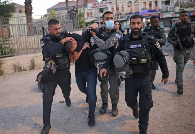 Israeli police forces arrest a Palestinian near the Damascus Gate in East Jerusalem as ultra-nationalists participate in the flag march near the Old City of Jerusalem on June 15, 2021.