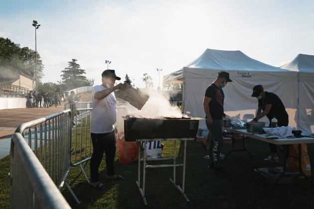 Behind the stand where the 7 Dreams association sells sandwiches and drinks.  The volunteers prepare the merguez.