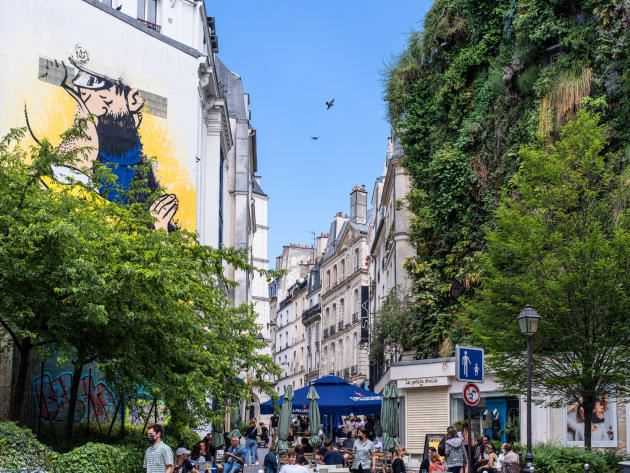 At the corner of rue d'Aboukir and des Petits-Carreaux, a work by street artist Combo dialogues with the green wall by botanist Patrick Blanc.