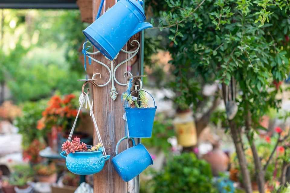 Painting flower pots: blue flower pots hang in the garden