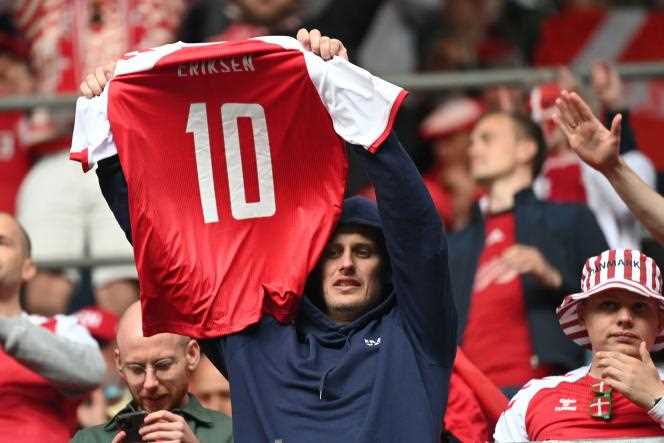 A supporter holds a shirt with Danish player Christian Eriksen's name on it after the latter's heart attack during a Euro match against Finland in June.