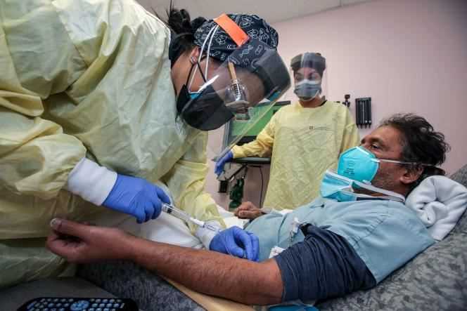 A nurse administers Dr. Prabakar Tummala an infusion of bamlanivimab, a monoclonal antibody, at Desert Valley Hospital on Thursday, December 17, 2020 in Victorville, California.
