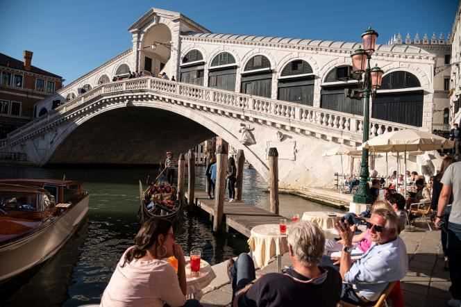 Tourists sit at a cafe near the Rialto Bridge in Venice, Italy on May 20, 2021.
