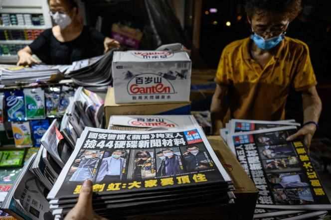 Employees at a newsstand sort through copies of the “Apple Daily” in Hong Kong in early June 18, 2021.