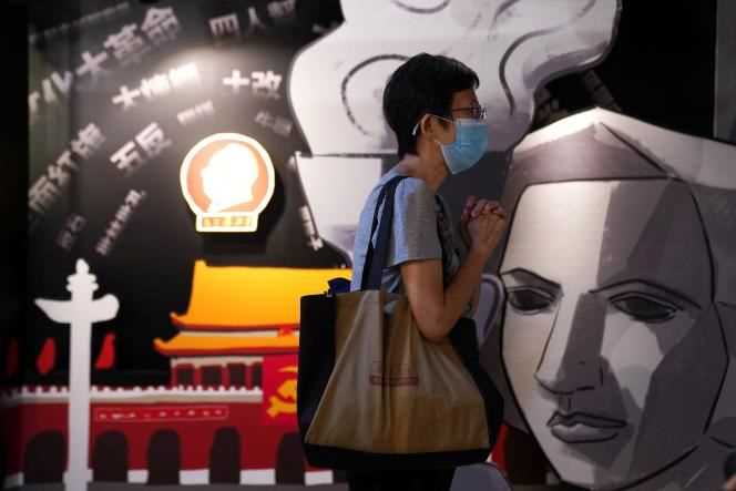 A visitor prays next to a painting of the Goddess of Democracy at the June 4 Museum, which commemorates the crackdown on Tiananmen Square in 1989, when it reopens in Hong Kong on May 30, 2021.
