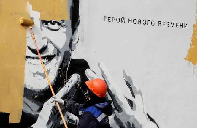 A worker repaints a portrait of the opponent Alexei Navalny in Saint Petersburg, Russia, April 28, 2021. Next to the portrait, it reads: 