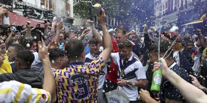 Scottish supporters have a beer shower before the game against England on June 18, in Leicester Square, central London (England).