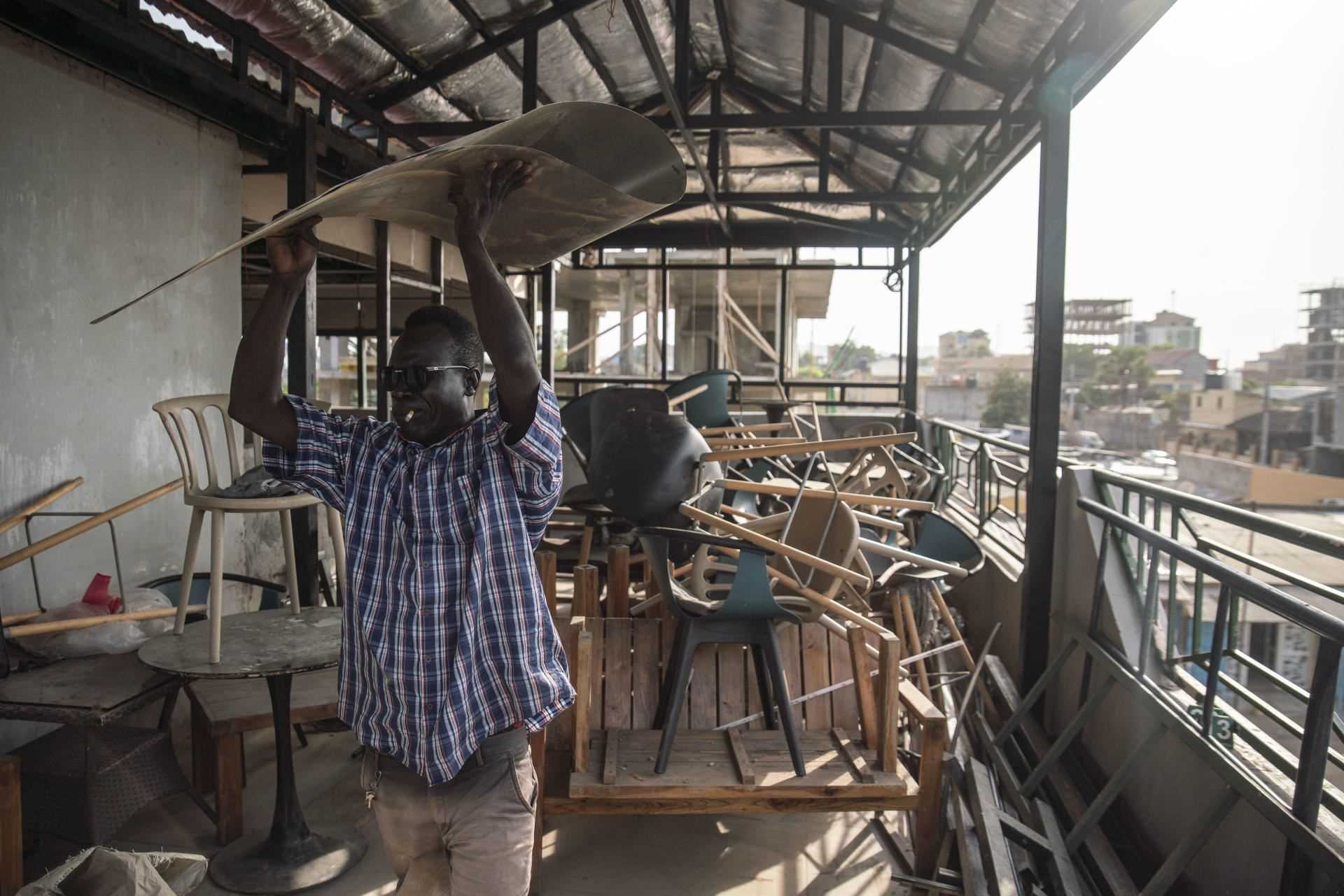 A South Sudanese worker rebuilds the roof of a hotel for its Eritrean owner in Juba on June 26, 2021.