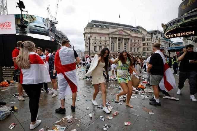 Fans force their way through the debris left at Piccadilly Circus on Sunday, July 11, before the final kicks off.