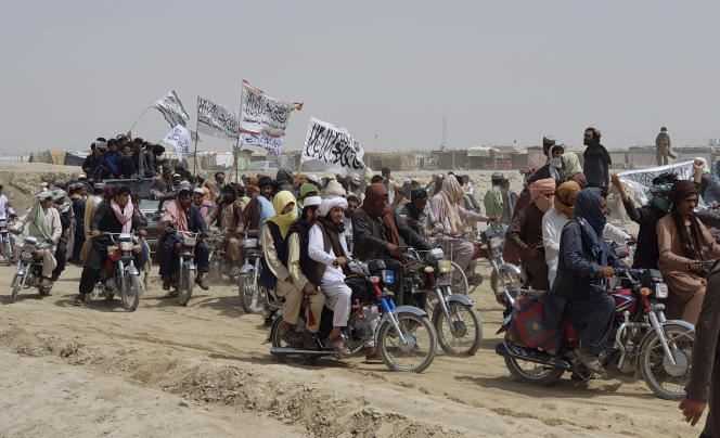 Afghans who support the Taliban carry their iconic white flag at Spin Boldak on July 14, 2021.