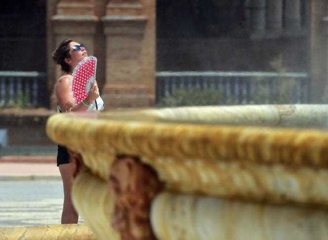 A woman tries to cool off near a fountain in Seville (Andalusia), July 10, 2021.