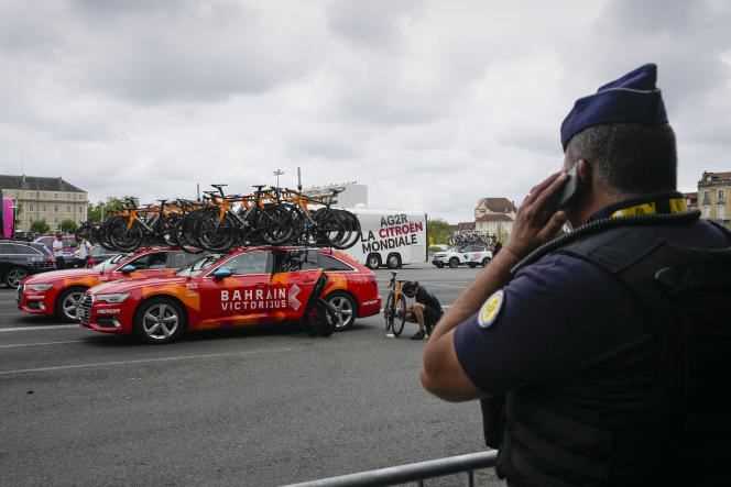 A gendarme monitors the cars of the Bahrain Victorious team before the start of the 18th stage of the Tour de France, in Pau, on July 15.