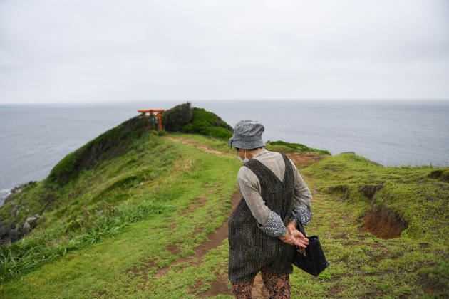 A resident of Iki Island goes to the shrine on a kilometer-long cliff by the Genkai Sea.  Nagasaki Prefecture, Japan, July 8, 2021.