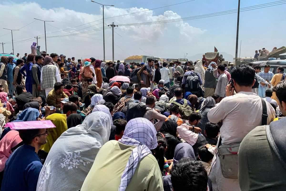 Afghan families wait to board a US military plane from the military sector of Kabul airport on Friday, August 20, 2021.
