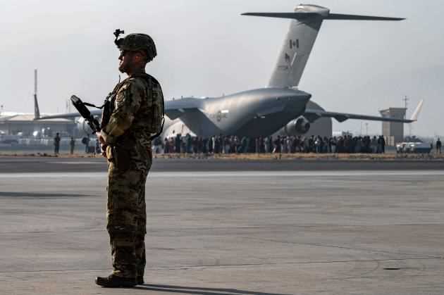 A photograph released by the US military shows a soldier guarding the boarding area for military planes at Kabul airport on Friday, August 20.