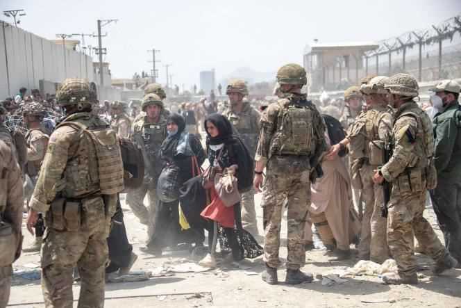 Members of the British and US armies evacuate people from Afghanistan at Kabul airport in August 2021.