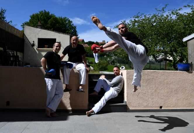 Karateka Steven Da Costa (right) trains in front of his father Michel and his brothers Jessie (left) and Logan (center), in Mont-Saint-Martin (Meurthe-et-Moselle), on May 5, 2020.