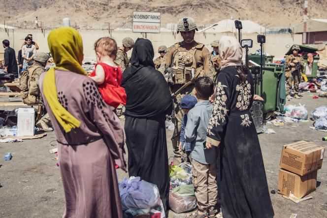 Marines greet Afghans waiting to be evacuated from Kabul military airport on Saturday, August 28.