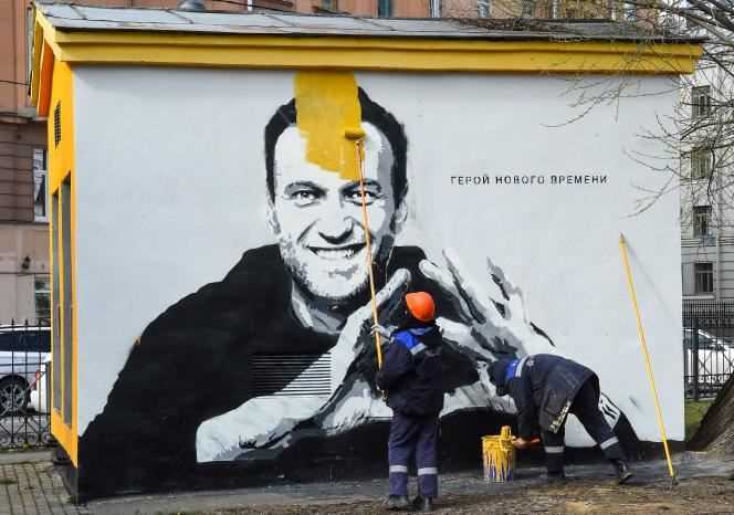 Workers cover graffiti depicting Russian opponent Alexei Navalny in St. Petersburg on April 28.