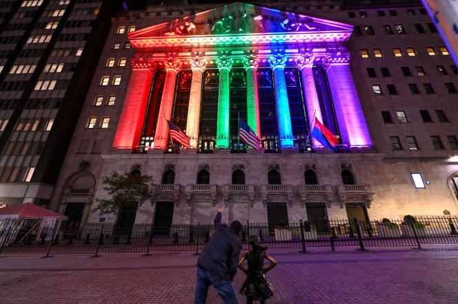 Kristen Visbal's Fearless Girl statue in front of the New York Stock Exchange, illuminated in the colors of the LGBT flag, on June 26, 2021.