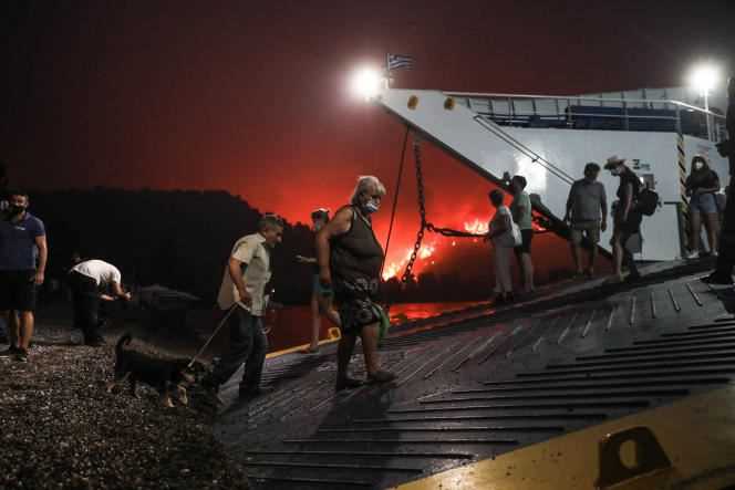 People evacuated by ferry as a fire approaches in Limni, a village on the island of Evia, Greece, August 6, 2021.