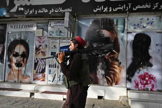 Taliban in front of a beauty salon, whose posters depicting women were tagged, on August 18, in Kabul.
