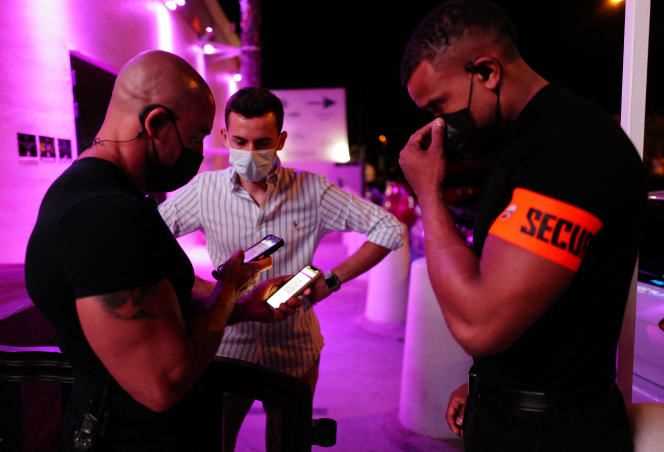 Security guards check a client's health pass at La Dune nightclub in La Grande Motte on July 9, 2021.