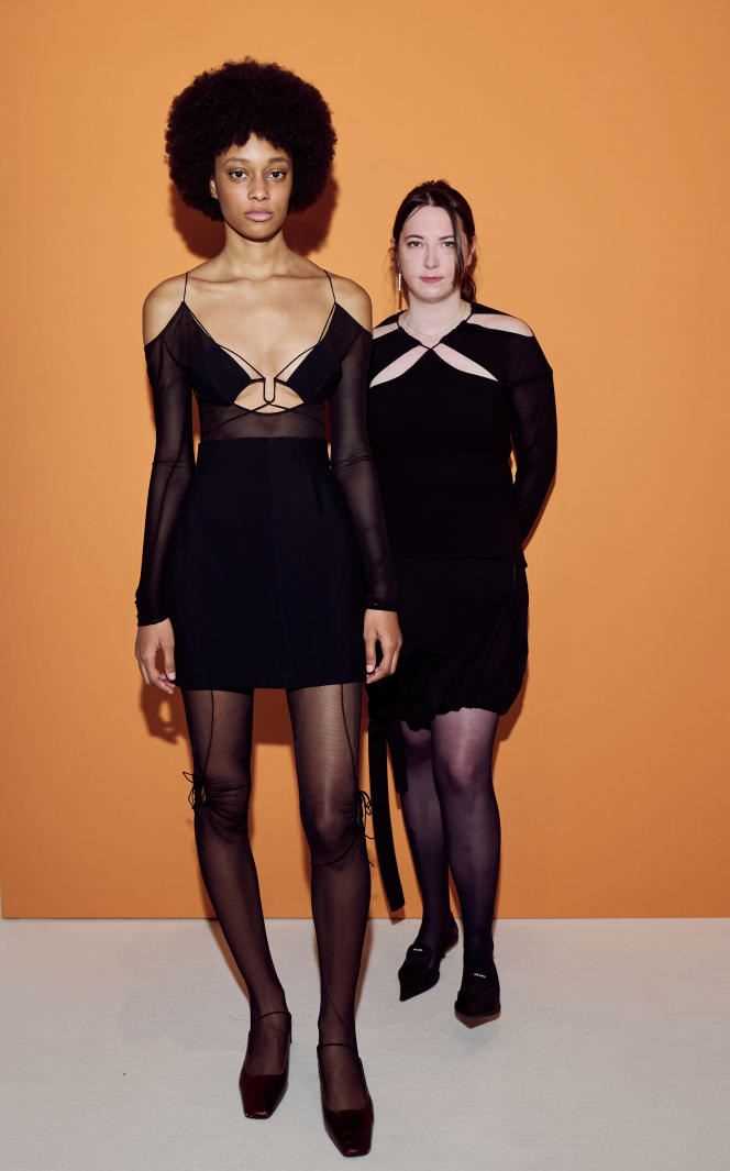 The designer Nensi Dojaka accompanied by a model, both wearing her creations.