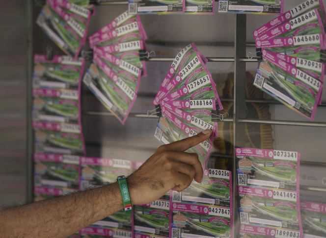 A customer indicates the lottery ticket he wants to buy, in an attempt to win one of the drug lords' possessions, put into play by the Mexican government, in Mexico City, September 13, 2021.