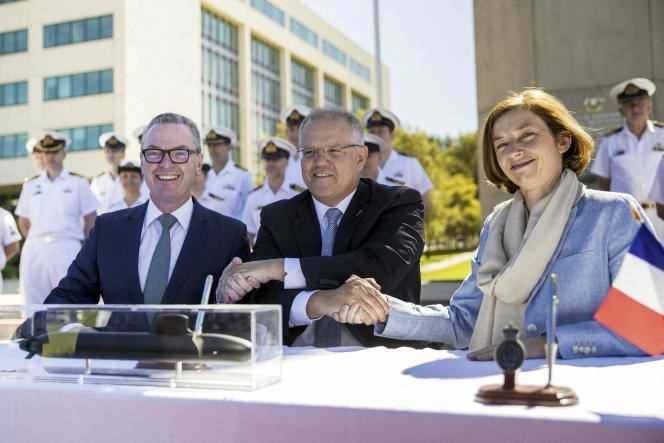 Australian Prime Minister Scott Morrison shaking hands with Australian Defense Minister Christopher Pyne and French Defense Minister Florence Parly after signing a contract to sell submarines in Canberra on February 11, 2019.