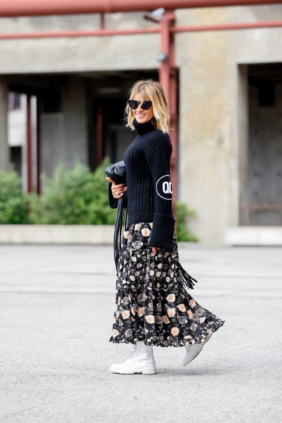 Floral skirt: woman wears a black sweater and a skirt with a floral pattern
