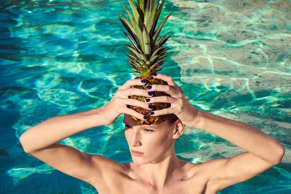 Fruits for beauty: woman in the pool with pineapple