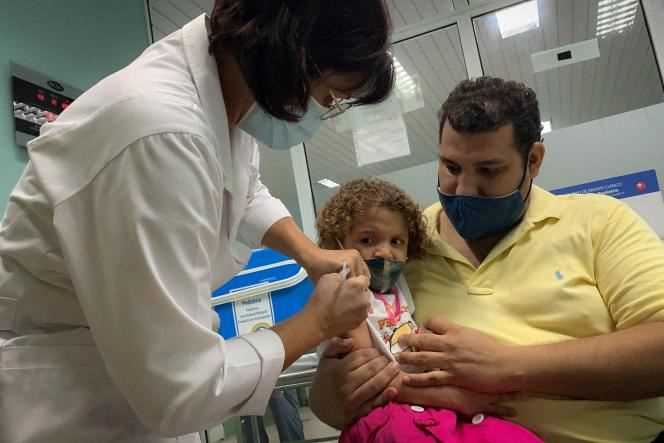Roxana, 3, in the arms of her father Pedro Montano, receives the vaccine against the Covid-19 Soberana Plus, on August 24, 2021, as part of a clinical study on the vaccination of children carried out at the Juan-hospital. Manuel-Marquez from Havana.