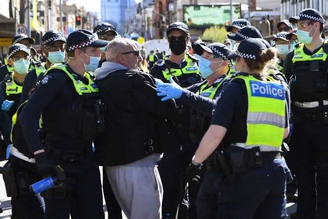 Police detain a protester, Saturday, September 18, in Melbourne, Australia.