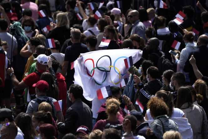 Fans wave an Olympic flag in the Trocadéro gardens in Paris on August 21, 2021.