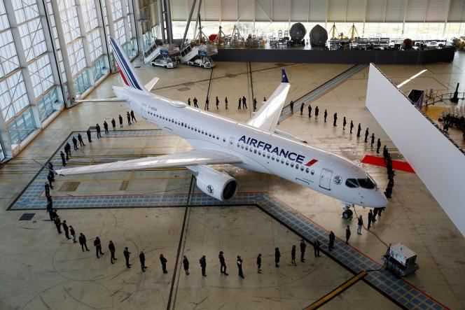 Air France employees around an Airbus A220 in a hangar at Roissy-Charles-de-Gaulle airport, in Roissy (Val-d'Oise), September 29, 2021.