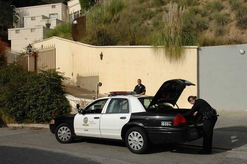Police officers stand in front of her home in the Hollywood Hills of LA on the day of Brittany Murphy's death on December 20, 2009. Pop star Britney Spears lived here before the purchase in 2003.