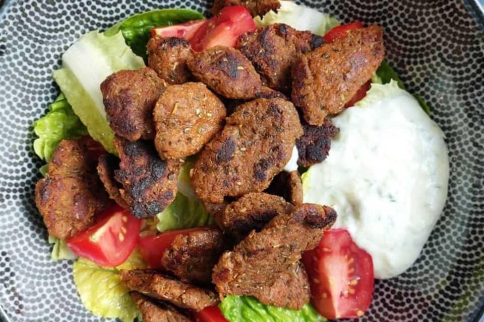 The vegan gyros from Early Green on lettuce leaves, tomatoes with tzatziki