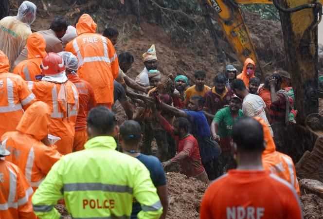 Rescuers carry the body of a victim after retrieving it from the wreckage of a house following a landslide caused by heavy rains in the village of Kokkayar, Idukki district, Idukki 'Southern State of Kerala, India, October 17, 2021.