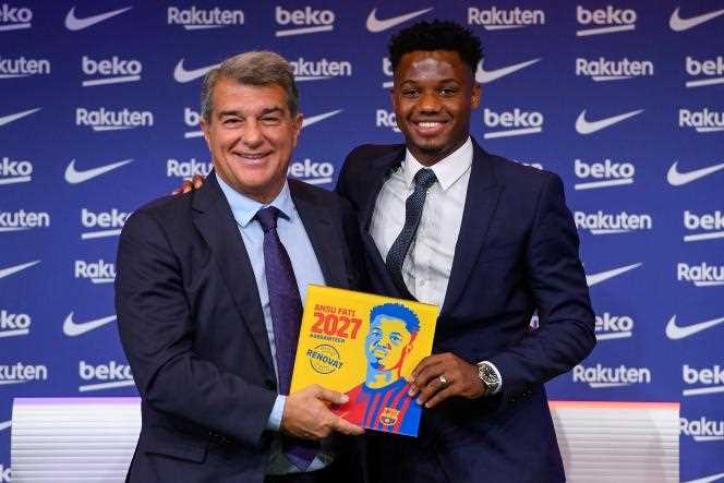 Ansu Fati (right) smiling alongside his president, Joan Laporta, during the ceremony to extend his contract until 2027, in Barcelona, ​​on October 21, 2021.