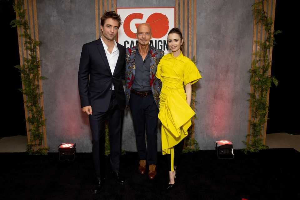 Lilly Collins appears to be standing on a yellow stilt