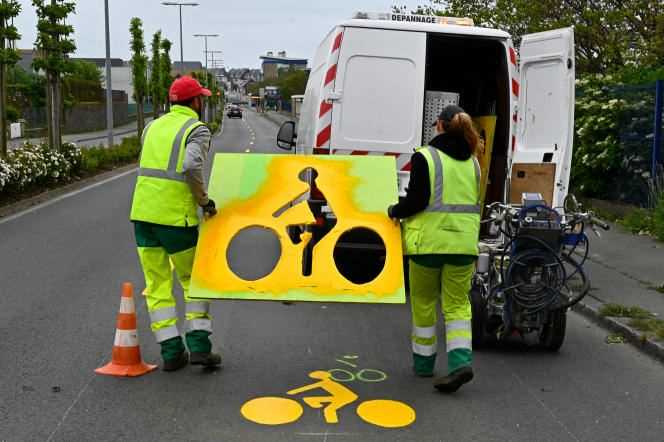 The “quarter-hour city” must allow people to live while minimizing their trips.  Municipal employees use stencils to mark a line of cyclist traffic on a road in Saint-Malo (Brittany), May 11, 2020.