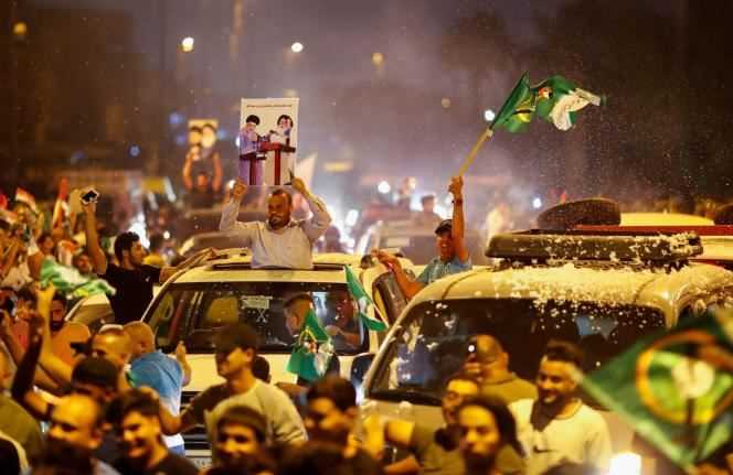 Iraqi supporters of the Moqtada Al-Sadr movement celebrate the preliminary results of the Iraqi parliamentary election in Baghdad on October 11, 2021.
